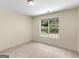 Bright bedroom featuring neutral carpet and walls and a window view of lush backyard greenery at 264 Keller Dr, Mcdonough, GA 30252