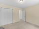 Beige bedroom featuring neutral carpet and walls, closet doors, and an entrance doorway at 264 Keller Dr, Mcdonough, GA 30252