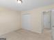 Beige bedroom featuring neutral carpet and walls, closet doors, and an entrance doorway at 264 Keller Dr, Mcdonough, GA 30252