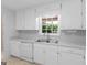 Bright kitchen boasts white cabinets, countertops, and a stainless steel sink under a window at 264 Keller Dr, Mcdonough, GA 30252