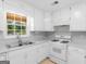 Bright kitchen boasts white cabinets, countertops, and a stainless steel sink under a window at 264 Keller Dr, Mcdonough, GA 30252