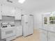Bright eat-in kitchen features white cabinetry, appliances and a view of the outdoors at 264 Keller Dr, Mcdonough, GA 30252