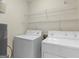 Well lit laundry room includes a washer, dryer, and wire shelving for storage at 264 Keller Dr, Mcdonough, GA 30252
