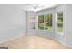 Bright room features three large windows with a ceiling fan and neutral walls and flooring at 264 Keller Dr, Mcdonough, GA 30252