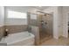 Bathroom featuring a separate tub and shower, and neutral tile at 7435 Ansley Park Way, Cumming, GA 30028