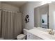 Neutral bathroom with a vanity, toilet, and shower-tub combo with modern curtain at 7435 Ansley Park Way, Cumming, GA 30028