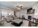 Open-concept living room featuring a stone fireplace and hardwood floors, seamlessly connected to the kitchen at 7435 Ansley Park Way, Cumming, GA 30028