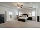 Spacious main bedroom with tray ceiling, fan, and plush carpet, offering a tranquil retreat at 7435 Ansley Park Way, Cumming, GA 30028