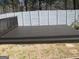 Dark wood back deck with railings and space for entertaining with an enclosed privacy fence at 7564 Mountain Ridge Ln, Lithonia, GA 30058