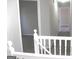Upstairs hallway with neutral carpet and paint and white banister detail at 7564 Mountain Ridge Ln, Lithonia, GA 30058