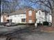 Exterior view of the townhome with parking, covered porches, and a combination of brick and vinyl siding at 4000 Orchard Hill Ter, Stone Mountain, GA 30083