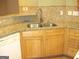 A well lit kitchen corner with modern faucet, stainless steel sink and granite countertops at 4000 Orchard Hill Ter, Stone Mountain, GA 30083