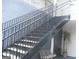 A staircase with metal railings leads to upper-level condos and a small outdoor seating area at 4000 Orchard Hill Ter, Stone Mountain, GA 30083