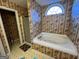 Bathroom featuring a soaking tub with jacuzzi jets and patterned wallpaper at 5627 Isleworth Ct, Atlanta, GA 30349