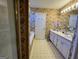 Traditional bathroom featuring a double sink vanity with floral wallpaper accents at 5627 Isleworth Ct, Atlanta, GA 30349