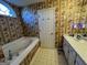 Bathroom featuring a soaking tub with jacuzzi jets and patterned wallpaper at 5627 Isleworth Ct, Atlanta, GA 30349