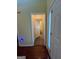 Hallway with hardwood floors, neutral walls, and framed doorways showing access to bathroom at 5627 Isleworth Ct, Atlanta, GA 30349