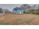 Exterior view of a blue home featuring a large, empty yard and a side door with a screened-in porch at 1730 Spring Ne St, Conyers, GA 30012