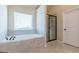 Bright bathroom offers a large window, bathtub, and a glass-enclosed shower at 171 Osier Dr, Mcdonough, GA 30252
