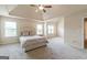 Spacious bedroom featuring a tray ceiling, ceiling fan and natural light at 171 Osier Dr, Mcdonough, GA 30252