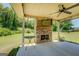 Relaxing covered back patio has an outdoor fireplace, ceiling fan and spacious seating at 70 Country Meadows Ln, Covington, GA 30014