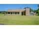 Spacious backyard with green grass and a partial view of the exterior of the home at 70 Country Meadows Ln, Covington, GA 30014