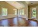 Bright, empty dining room featuring hardwood floors, wainscoting, neutral paint, a modern chandelier, and large windows at 70 Country Meadows Ln, Covington, GA 30014