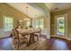 Bright dining room features hardwood floors, wainscoting, neutral paint, large windows, and a wooden dining table at 70 Country Meadows Ln, Covington, GA 30014