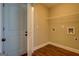Neutral laundry room features hardwood floors, a metal rack, and washer/dryer hookups at 70 Country Meadows Ln, Covington, GA 30014