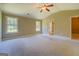 Bright, spacious bedroom with a tray ceiling, soft carpet, a ceiling fan, neutral paint, and walk-in closet at 70 Country Meadows Ln, Covington, GA 30014