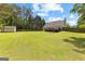 Spacious backyard featuring a storage shed, deck, mature trees and a fenced-in yard at 75 Mcintosh Estates Ct, Sharpsburg, GA 30277