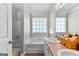 Bright primary bathroom with double sinks, tub, and large window at 75 Mcintosh Estates Ct, Sharpsburg, GA 30277