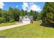 Landscaped front yard and home exterior featuring mature trees and a two car garage at 75 Mcintosh Estates Ct, Sharpsburg, GA 30277
