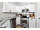 Well-lit kitchen features stainless steel appliances, granite countertops, and crisp white cabinetry at 75 Mcintosh Estates Ct, Sharpsburg, GA 30277