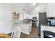 The bright kitchen offers white cabinets, stainless steel appliances and a granite countertop at 75 Mcintosh Estates Ct, Sharpsburg, GA 30277