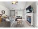 Bright living room featuring a cozy fireplace, vaulted ceilings, and a large sectional sofa at 75 Mcintosh Estates Ct, Sharpsburg, GA 30277