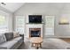 Cozy living room features a brick fireplace, ample natural light, and a comfortable sofa arrangement at 75 Mcintosh Estates Ct, Sharpsburg, GA 30277