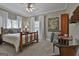 Well-lit bedroom features a wooden bed frame, large windows, and hardwood furniture at 1000 Pleasance Grv, Peachtree City, GA 30269