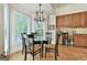 Dining area features a glass table, elegant lighting, and natural light at 1000 Pleasance Grv, Peachtree City, GA 30269