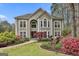 Stucco home featuring professionally landscaped yard with mature trees, colorful azaleas and manicured lawn at 1000 Pleasance Grv, Peachtree City, GA 30269