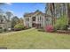 This large home has mature trees, colorful azaleas, and a sprawling green lawn at 1000 Pleasance Grv, Peachtree City, GA 30269