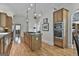 Bright kitchen boasts wood cabinets, center island with cooktop, and stainless-steel double ovens at 1000 Pleasance Grv, Peachtree City, GA 30269