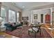 Bright living room with a plush green couch, elegant glass coffee table, and detailed oriental rug at 1000 Pleasance Grv, Peachtree City, GA 30269