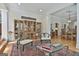 Bright and airy living room with a detailed oriental rug, glass coffee table, and elegant display cases at 1000 Pleasance Grv, Peachtree City, GA 30269