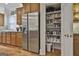 Walk-in pantry featuring plenty of shelving space for food storage next to stainless steel refrigerator at 1000 Pleasance Grv, Peachtree City, GA 30269