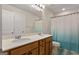 Bright bathroom featuring a double sink vanity and shower with modern blue curtain at 823 Mackay Crk, Woodstock, GA 30188