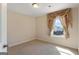 Empty carpeted bedroom bathed in natural light streaming through a window framed by decorative curtains at 823 Mackay Crk, Woodstock, GA 30188