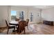 A view of the dining room with hardwood floors, windows, and a round wooden table with four chairs at 823 Mackay Crk, Woodstock, GA 30188