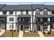 View of the townhome exteriors showing the front porches, black accents, and a street lamp at 823 Mackay Crk, Woodstock, GA 30188