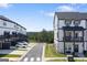View of the new construction townhome exteriors, featuring a road and parking space at 823 Mackay Crk, Woodstock, GA 30188